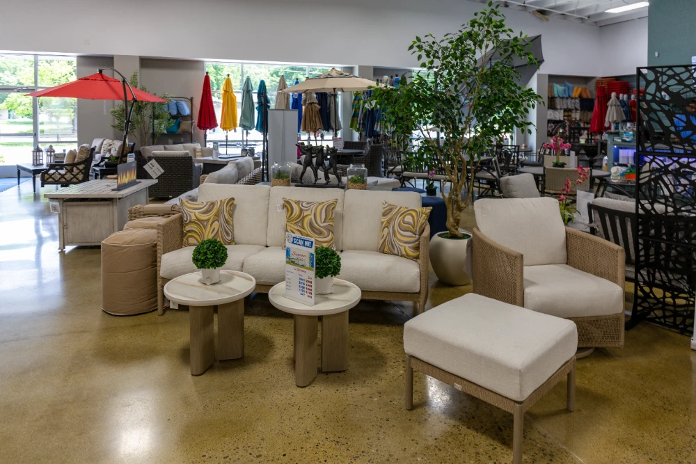 Modern outdoor patio furniture showroom displaying cream sofas and wooden tables for backyard living