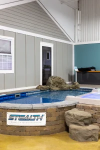 Stealth semi-inground pool display with decorative rocks in Cincinnati showroom