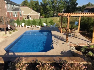 Backyard pool with wooden pergola, patio furniture, and residential outdoor living space