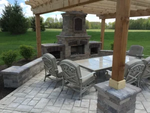 Luxurious outdoor patio furniture and fireplace under wooden pergola in backyard setting