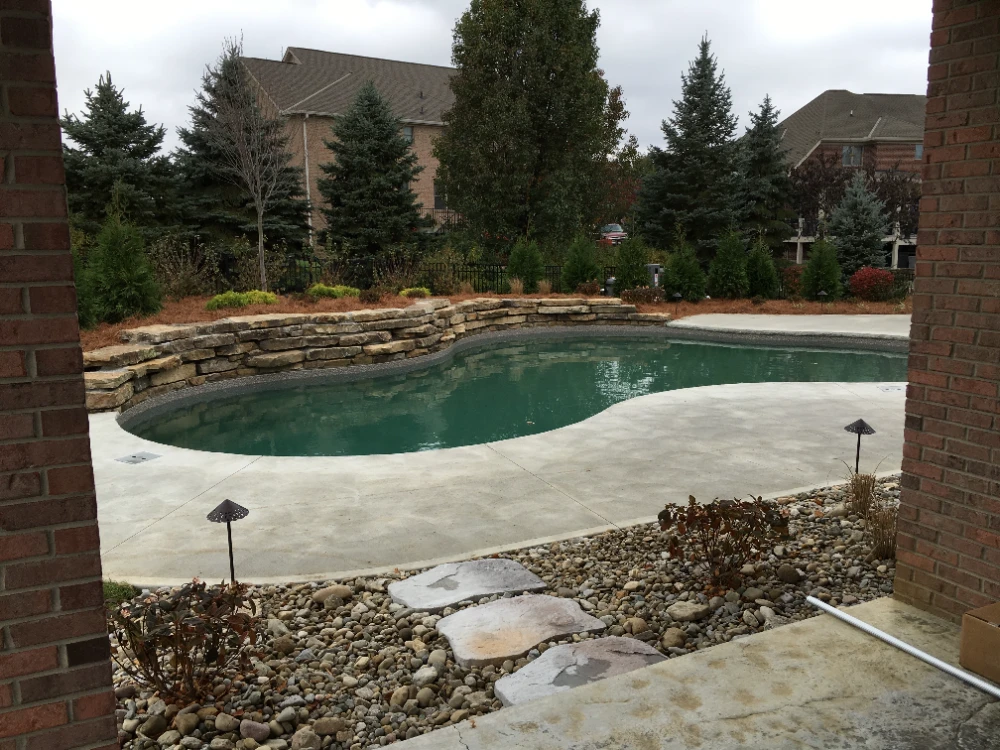 Custom backyard pool with stone patio and residential outdoor living space