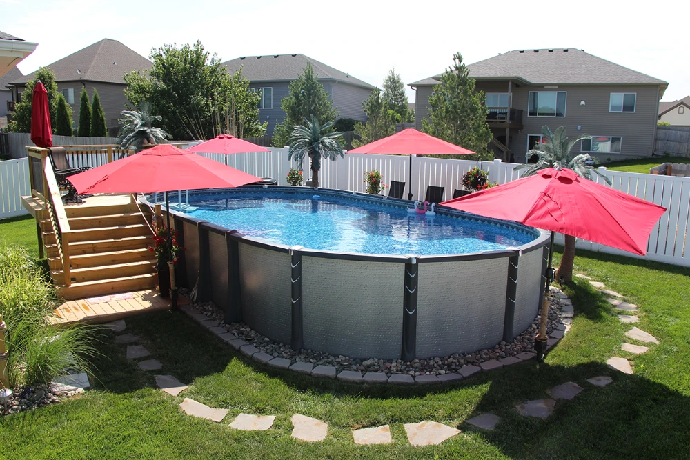 Above ground pool with red umbrellas and wooden deck in Cincinnati backyard