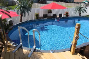 Above ground backyard pool with red umbrellas and outdoor patio furniture in Cincinnati