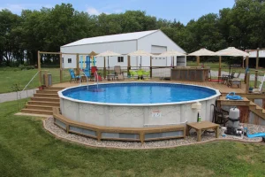 Above ground pool with wooden deck, patio furniture, and backyard outdoor living setup