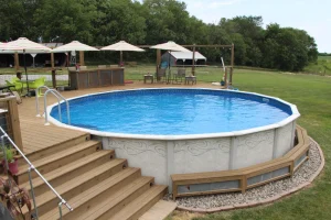 Above ground pool with wooden deck and patio umbrellas in backyard setting