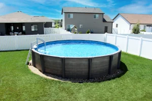 Large above ground pool with ladder in backyard surrounded by white fencing