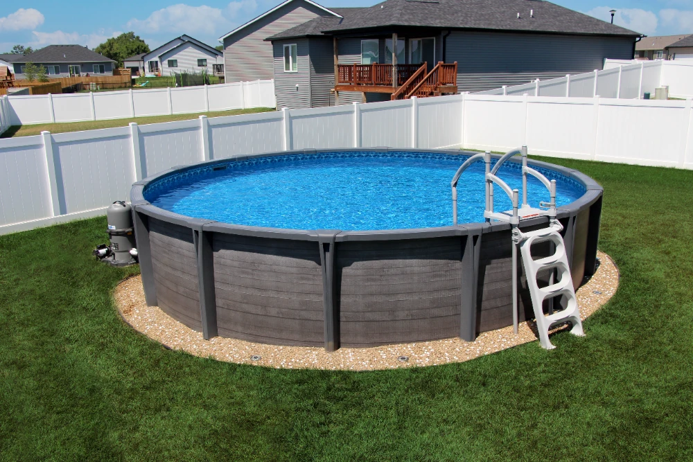 Above ground pool with gray frame in Cincinnati backyard surrounded by white fence