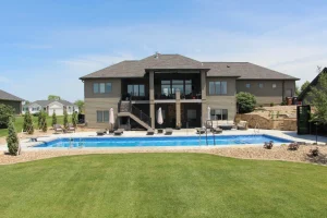Luxury backyard with rectangular pool, outdoor patio furniture, and multi-level home entertainment area