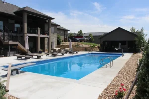 Luxury backyard pool with lounge chairs, patio furniture, and modern outdoor living space