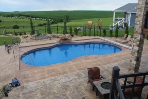 Luxurious backyard pool installation with patio furniture and manicured outdoor living space