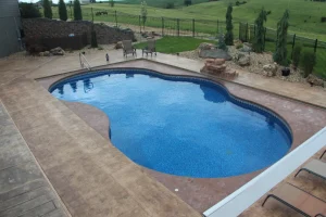 Custom backyard pool with concrete patio and outdoor living space in Cincinnati