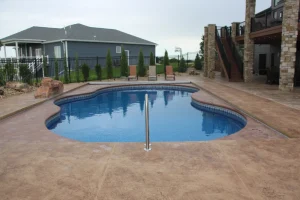 Custom backyard pool with concrete patio and outdoor living space