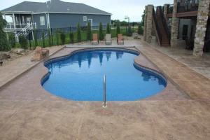 Custom backyard pool with concrete patio and outdoor living space in Cincinnati