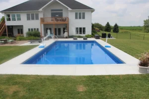 Modern backyard pool installation with white patio deck and two-story Cincinnati home