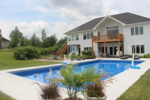 Luxurious backyard pool with outdoor patio furniture and modern residential home