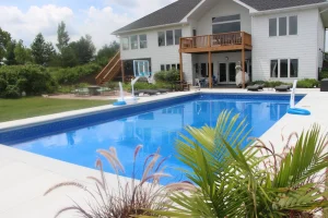 Luxury backyard pool with deck, basketball hoop, and modern outdoor patio furniture near Cincinnati home