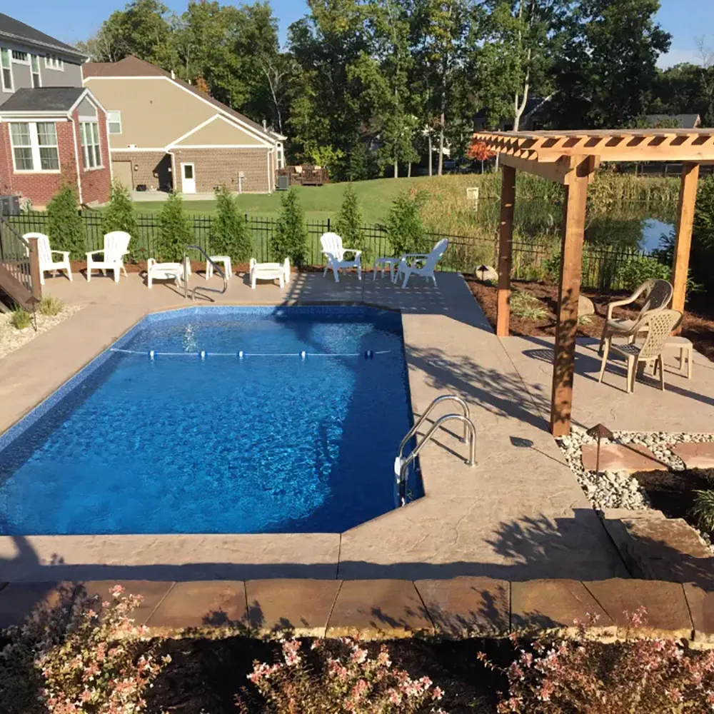 Backyard pool with wooden pergola, patio furniture, and residential outdoor living space