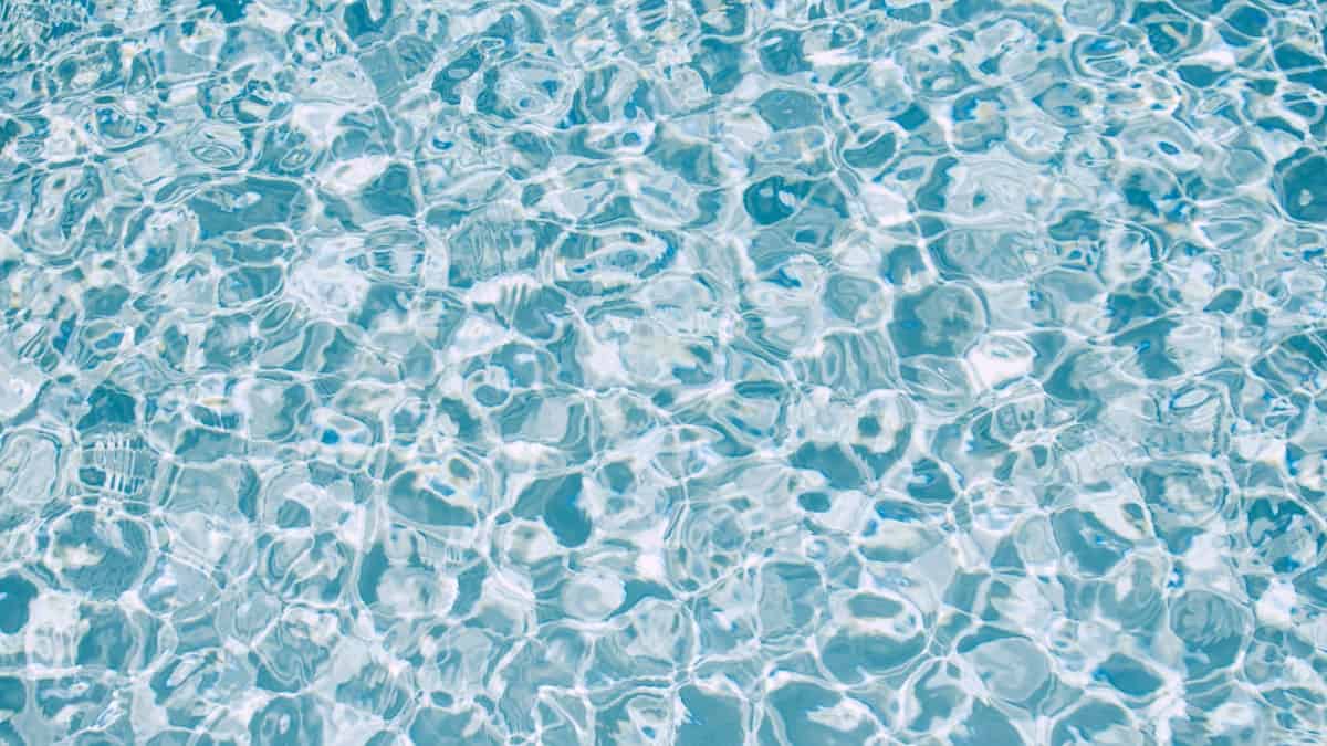 Sunlit clear blue swimming pool water showing properly chlorinated water in a Cincinnati backyard pool