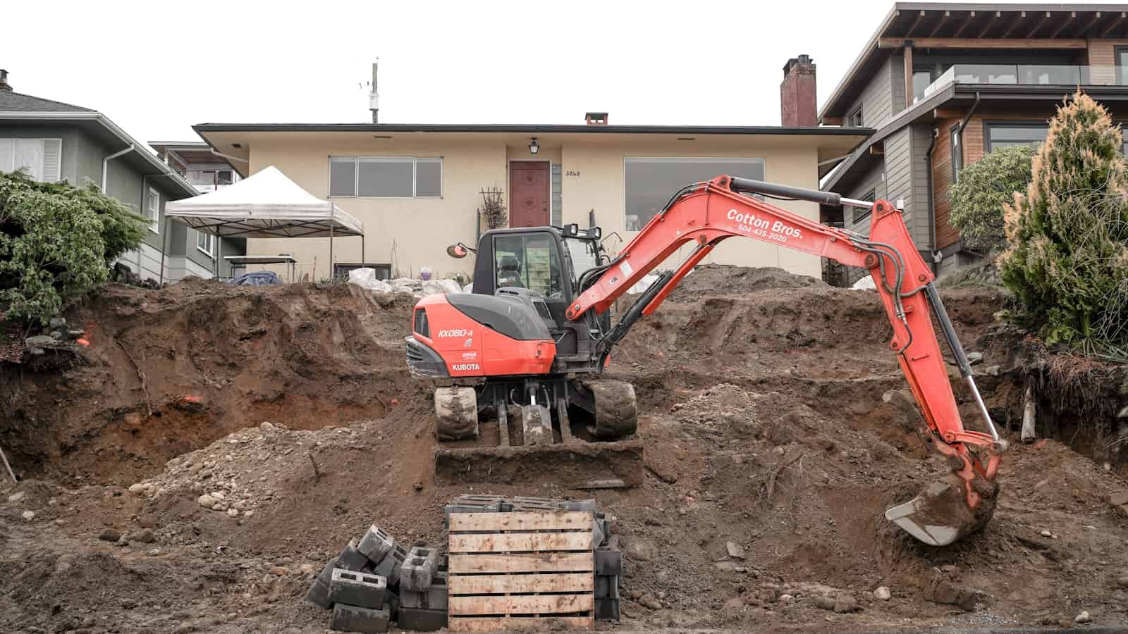 Excavator digging for a new inground swimming pool in a residential backyard