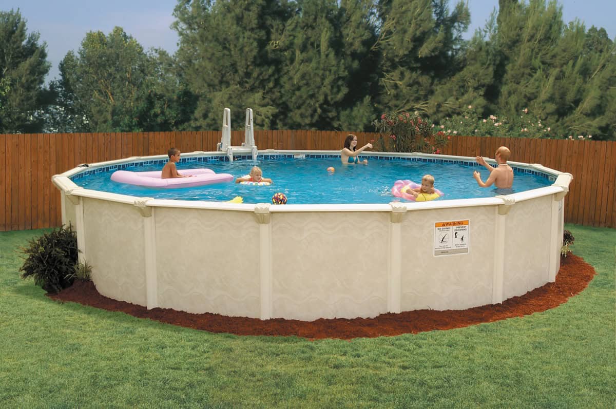 Embassy Century above ground pool with a creamy tan wall installed in a backyard