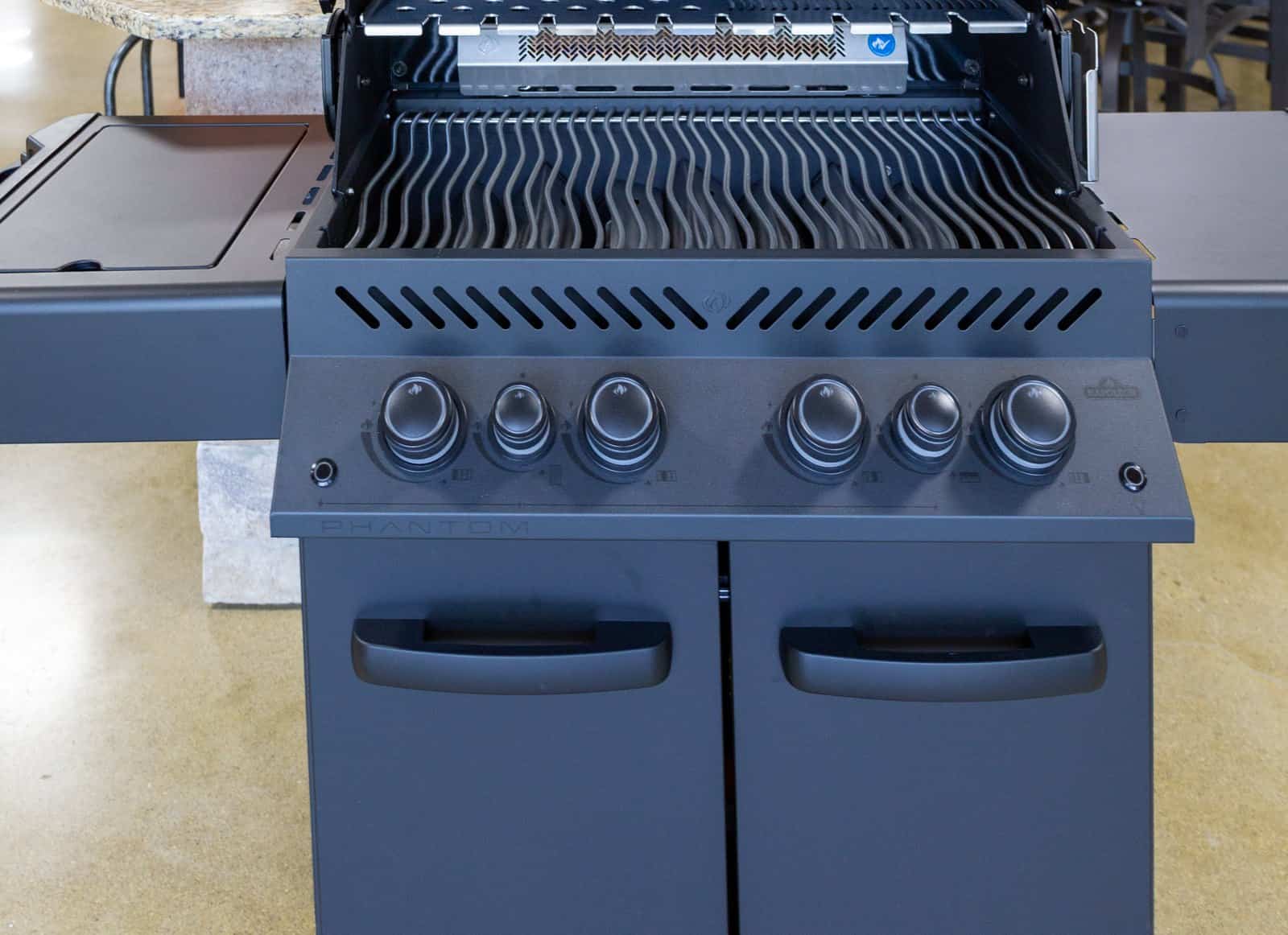 Napoleon four burner gas grill with the lid open and the cooking grates in view on the Cincinnati Pool and Patio showroom floor on Reading Road, the way we recommend comparing grills before you buy